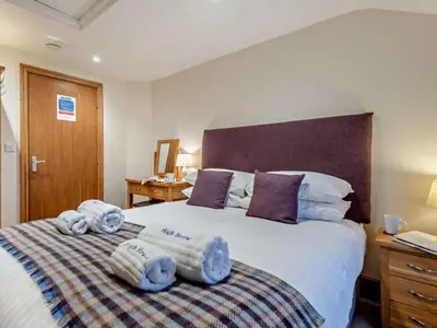 a bedroom with a large bed with towels on it at 3 Bed in Penrith oc-sz247 in Dockray