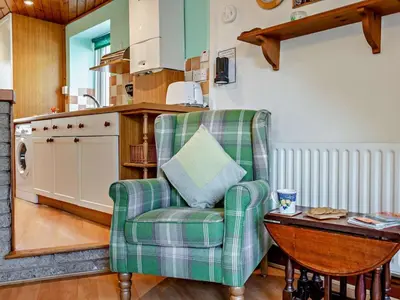 a living room with a green chair and a table at 2 Bed in Keswick oc-sz145 in Braithwaite
