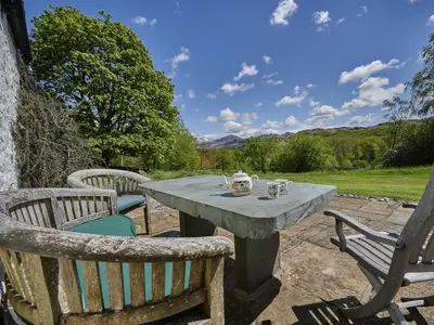 a table with two chairs and a tea set on it at 5 Bed in Holmrook oc-sz259 in Eskdale