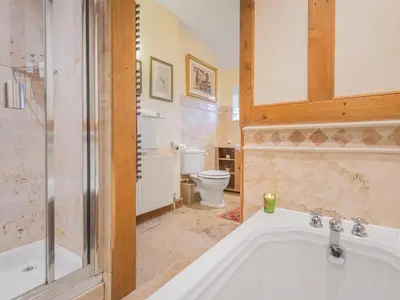 a bathroom with a tub and a toilet at 5 Bed in Holmrook oc-sz259 in Eskdale