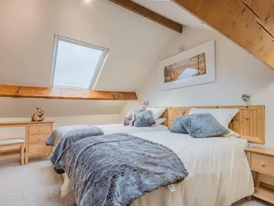 two beds in a attic bedroom with a window at 3 Bed in Keswick oc-sz227 in Threlkeld