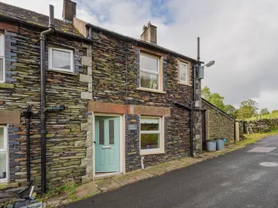 a stone house with a green door on a street at 3 Bed in Keswick oc-sz227 in Threlkeld