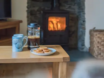 a table with a plate of cookies and a cup of coffee at 3 Bed in Keswick oc-sz227 in Threlkeld