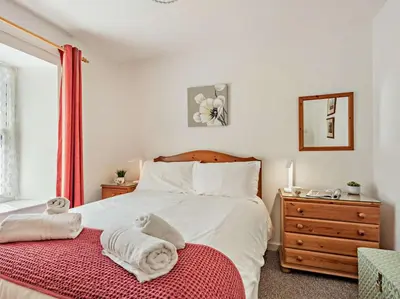 a bedroom with a bed and a dresser and a mirror at 2 Bed in Keswick SZ027 in Keswick