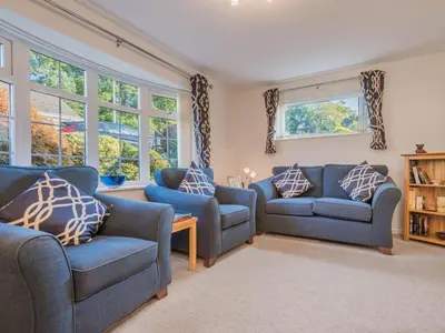 a living room with two blue couches and windows at 1 Bed in Keswick oc-sz437 in Keswick