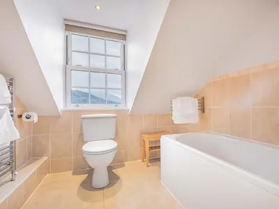 a bathroom with a toilet and a tub and a window at 2 Bed in Keswick SZ494 in Keswick