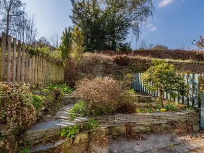 a garden with a stone wall and a fence at 2 Bed in Keswick oc-sz378 in Portinscale