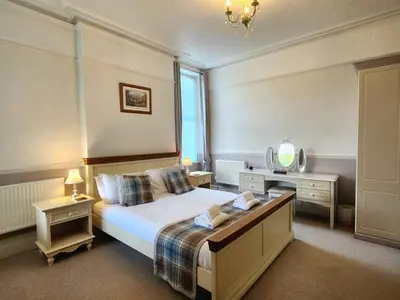 a bedroom with a large bed and a mirror at 2 Bed in Holmrook oc-sz464 in Beckfoot