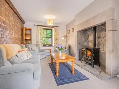 a living room with a large stone fireplace at 2 Bed in Penrith oc-sz218 in Mosedale