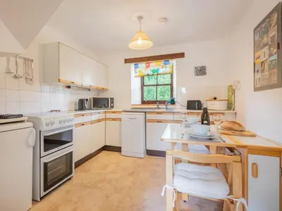 a kitchen with white appliances and a wooden table at 2 Bed in Penrith oc-sz218 in Mosedale