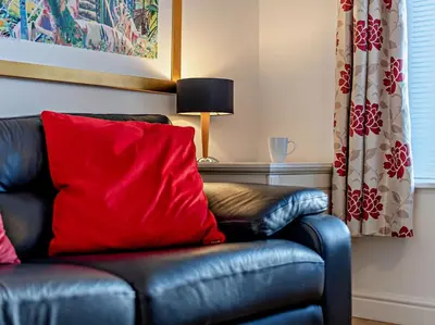 a leather couch with a red pillow in a living room at 1 Bed in Keswick SZ127 in Keswick