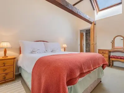a bedroom with a large bed with a red blanket at 2 Bed in Penrith oc-sz092 in Mosedale