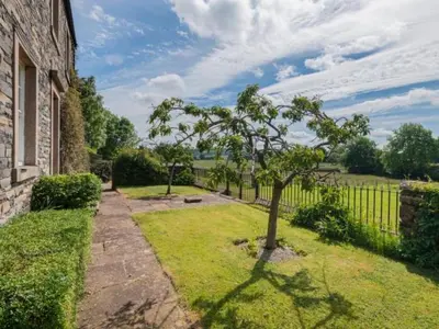 a tree in a yard next to a fence at 2 Bed in Penrith oc-sz092 in Mosedale