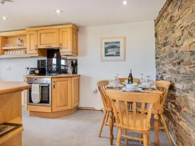a kitchen with a table and chairs and a stone wall at 2 Bed in Penrith oc-sz092 in Mosedale