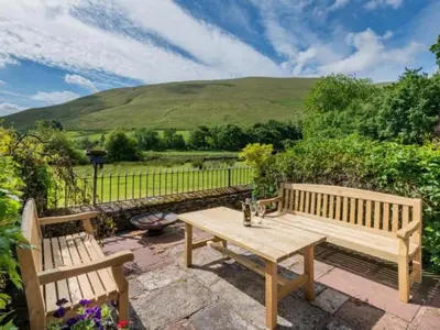 two wooden benches sitting next to a wooden table at 2 Bed in Penrith oc-sz092 in Mosedale