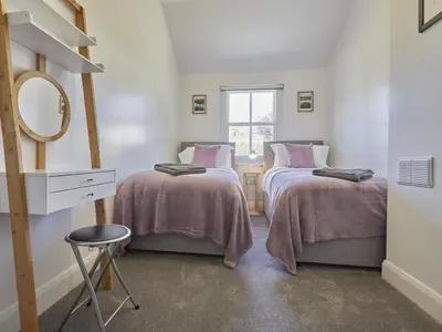 a bedroom with two beds and a mirror and a stool at 2 Bed in Keswick SZ011 in Keswick