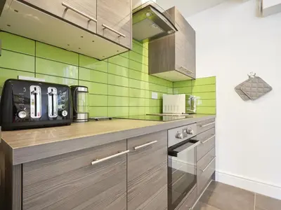 a kitchen with green tiles on the wall at 2 Bed in Keswick SZ011 in Keswick