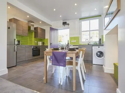 a kitchen with a wooden table and purple chairs at 2 Bed in Keswick SZ011 in Keswick