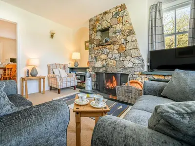 a living room with two couches and a stone fireplace at 3 Bed in Borrowdale SZ234 in Rosthwaite