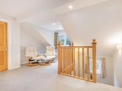 a living room with two chairs and a staircase at 4 Bed in Newlands Valley SZ204 in Braithwaite