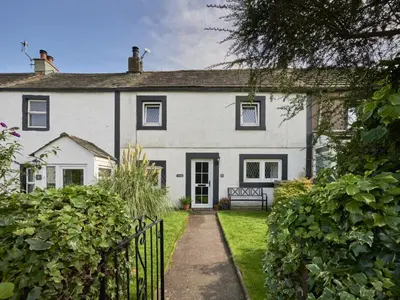 a white house with a gate in front of it at 2 Bed in Workington oc-sz323 in Camerton