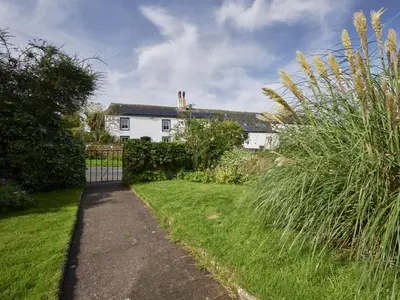 a white house with a fence and a grass yard at 2 Bed in Workington oc-sz323 in Camerton