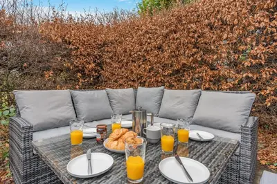 a table with plates of food and glasses of orange juice at 3 Bed in Keswick oc-84638 in Keswick