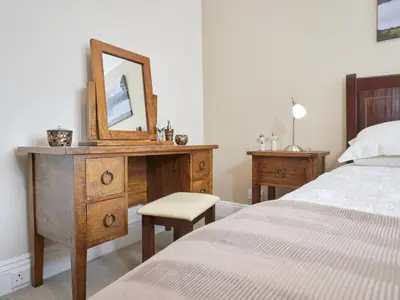 a bedroom with a bed and a dresser with a mirror at 4 Bed in Keswick oc-sz220 in Keswick