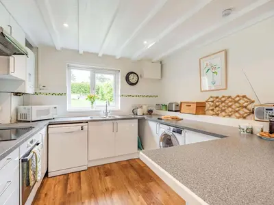 a large kitchen with white cabinets and a window at 3 Bed in Keswick oc-sz335 in Portinscale