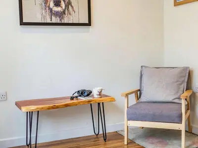 a table and a chair next to a wall at 3 Bed in Keswick oc-sz335 in Portinscale