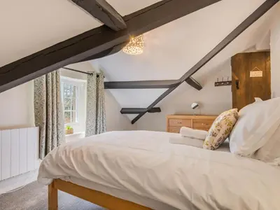 a bedroom with a large white bed with a wooden headboard at 2 Bed in Keswick oc-sz199 in Applethwaite