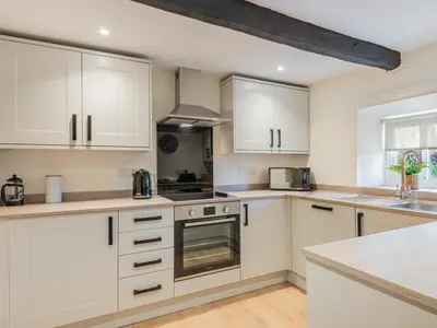 a kitchen with white cabinets and a stove top oven at 2 Bed in Keswick oc-sz199 in Applethwaite