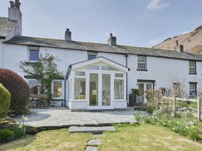 a white house with a conservatory and a patio at 3 Bed in Keswick oc-sz533 in Braithwaite