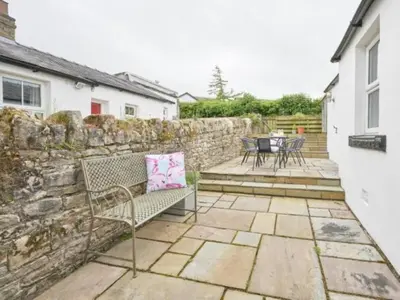 a patio with a bench and a stone wall at 4 Bed in Cockermouth oc-sz037 in Cockermouth