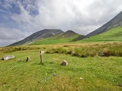 a fence in a field with mountains in the background at 2 Bed in Cockermouth oc-sz588 in Buttermere