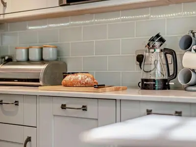 a kitchen counter with a loaf of bread on a cutting board at 3 Bed in Braithwaite SZ174 in Braithwaite