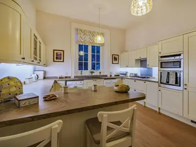 a large kitchen with white cabinets and a large island at 4 Bed in Ambleside oc-85294 in Grasmere