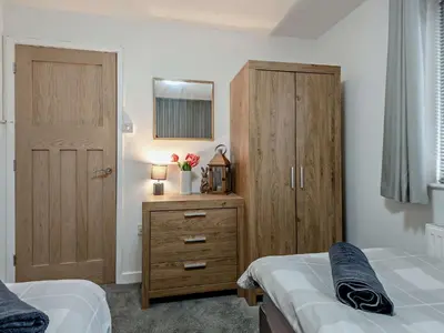 a bedroom with two beds and a wooden cabinet at 2 Bed in Keswick 86001 in Keswick