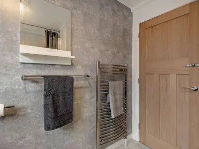 a bathroom with a towel rack and a mirror at 2 Bed in Keswick 86001 in Keswick
