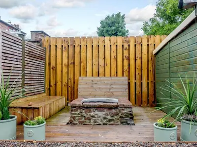 a wooden fence with a bench in front of a wooden deck at 4 Bed in Seascale oc-85807 in Gosforth