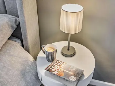 a table with a book and a lamp and a cup of coffee at 2 Bed in Keswick oc-87092 in Keswick