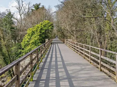 a bridge over a road with trees on both sides at 2 Bed in Keswick oc-87092 in Keswick