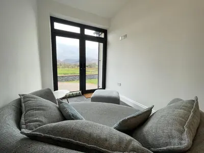 a living room with a couch and a window at Langrigg Cottage HOT TUB HIRE AVAILABLE in Portinscale