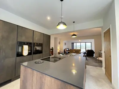 a kitchen and living room with a large counter top at Langrigg Cottage HOT TUB HIRE AVAILABLE in Portinscale