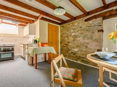 a kitchen with a table and a stone wall at 1 Bed in Penrith oc-88201 in Mosedale