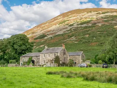 an old stone house in front of a hill at 1 Bed in Penrith oc-88201 in Mosedale