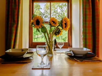 a wooden table with a vase of sunflowers in a vasemoil at 1 Bed in Penrith oc-88201 in Mosedale