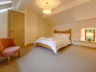 a bedroom with a bed and a chair and a window at 3 Bed in Cockermouth oc-88773 in Buttermere