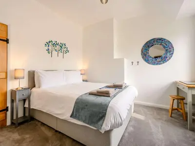 a bedroom with a large white bed and a table at 2 Bed in Keswick 88864 in Keswick