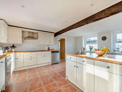 a kitchen with white cabinets and a tile floor at 5 Bed in Wigton oc-89496 in Torpenhow